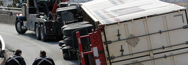 An overturned truck on a bridge