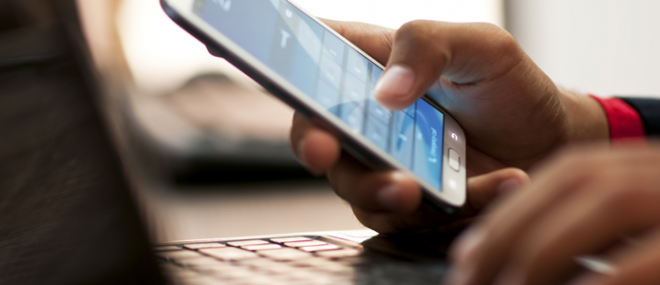 Man using a smartphone and laptop