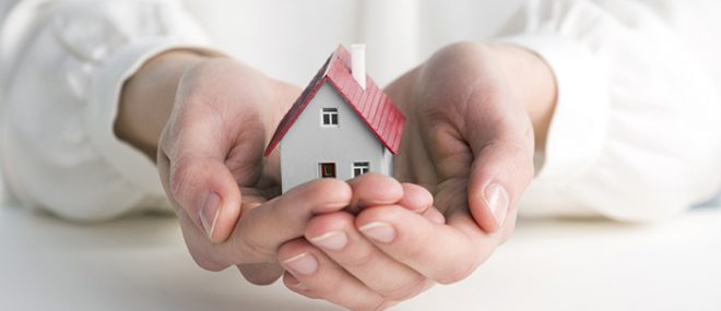 hands holding a small house.