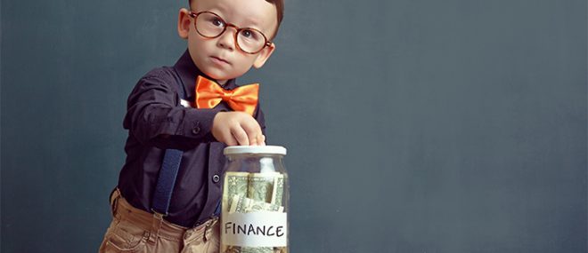 child putting money in a jar