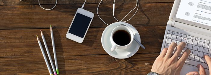 working at a table with coffee and smartphone