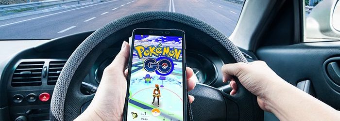 Image d’une personne conduisant une voiture en jouant à Pokemon
