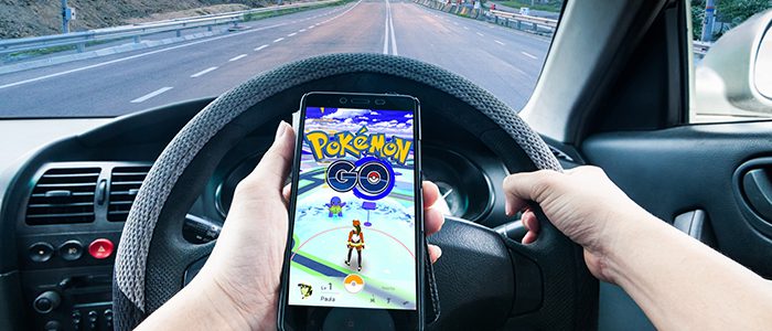 Image d’une personne conduisant une voiture en jouant à Pokemon
