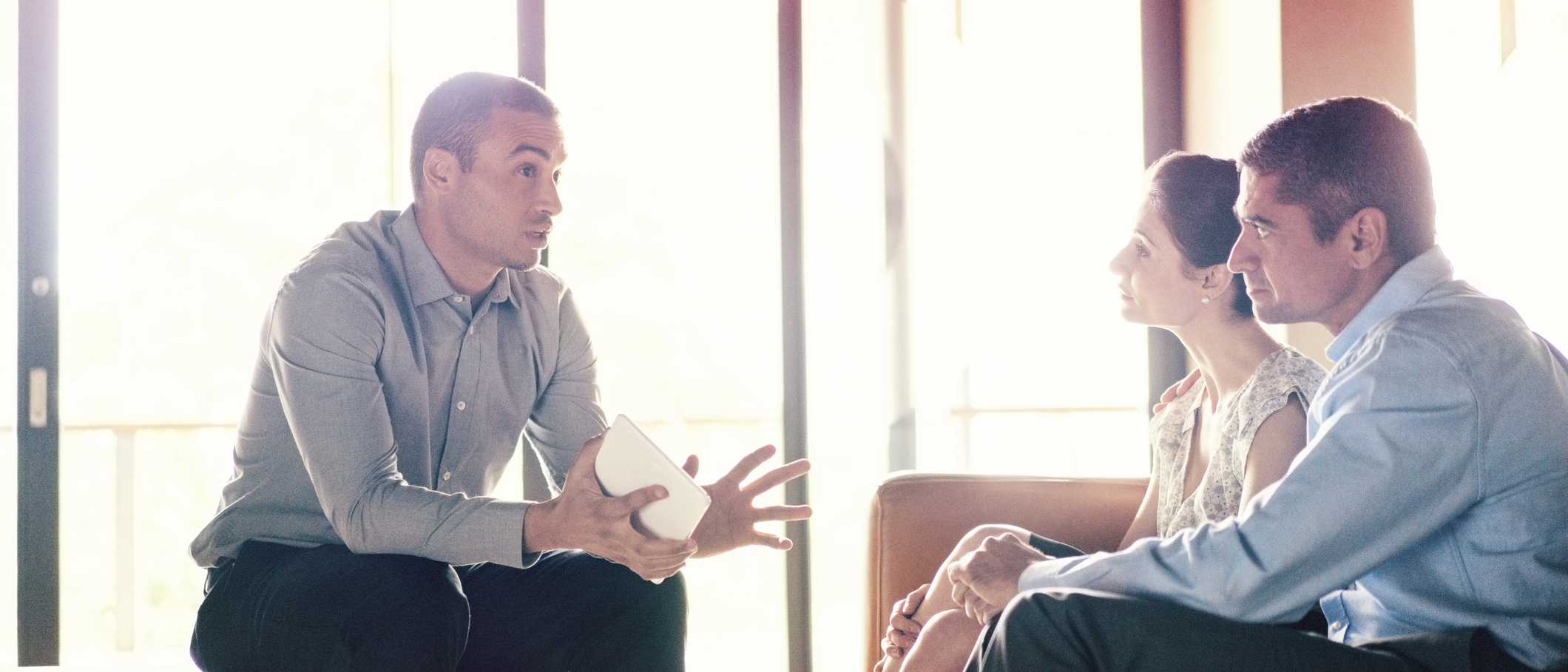 Confident businessman talking to couple.