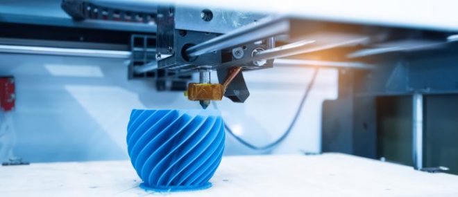 Photo d’une imprimante 3D imprimant un objet bleu