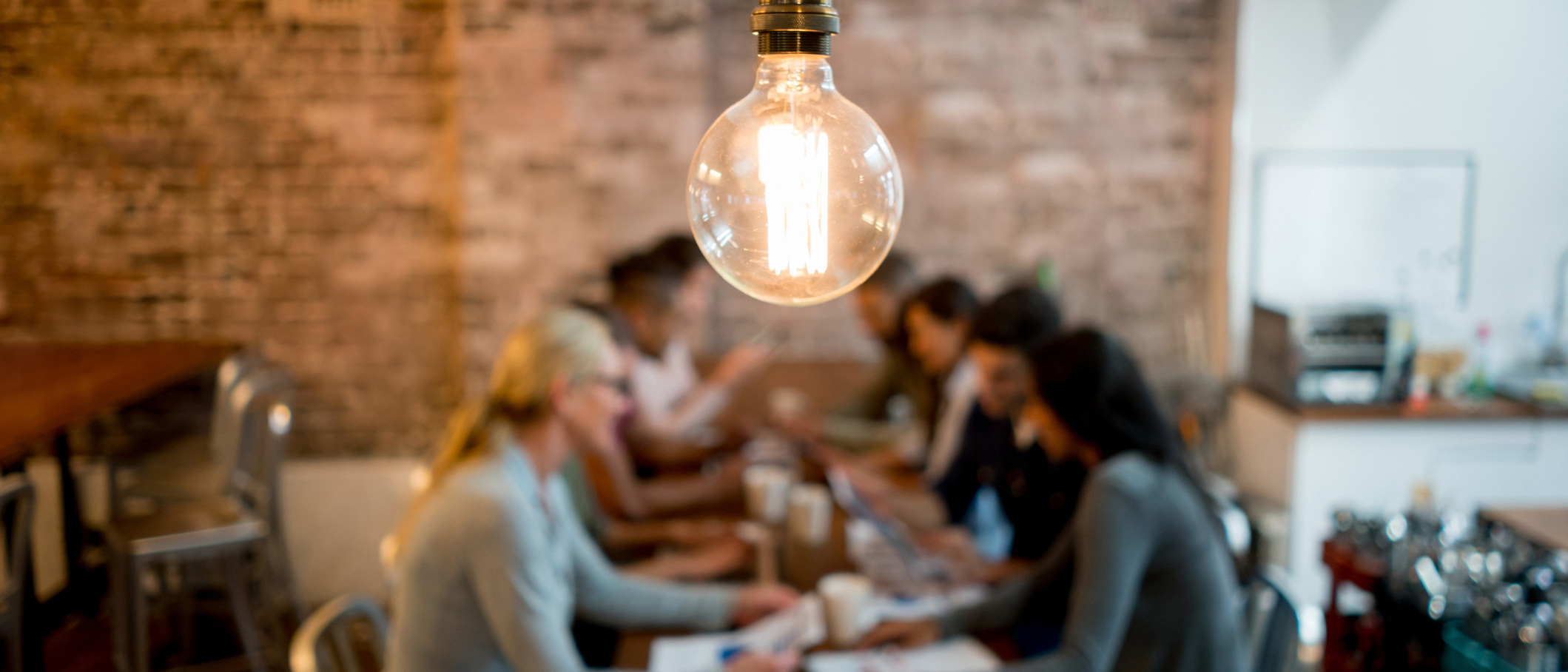 Remue-méninges sur les ressources des petites entreprises à une table sous une ampoule.