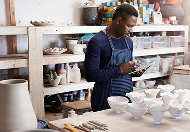 Un entrepreneur travaille dans son atelier de céramique.