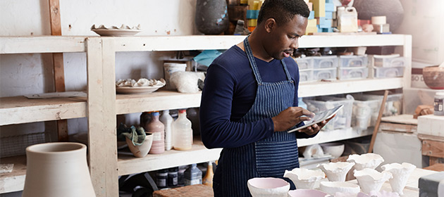 Un entrepreneur travaille dans son atelier de céramique.