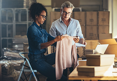 Deux propriétaires d’entreprise inspectent leurs vêtements.