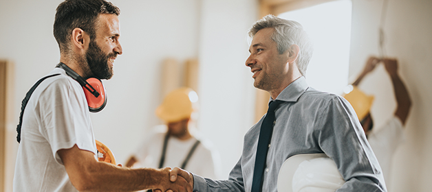 Un entrepreneur et un courtier de solutions de cautionnement se serrent la main.