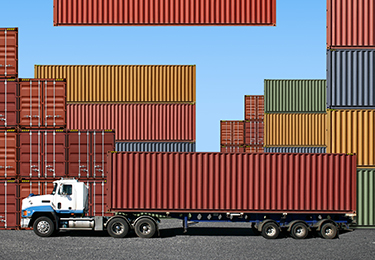 Un conteneur de transport est chargé sur un camion au port.