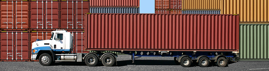 Un conteneur de transport est chargé sur un camion au port.