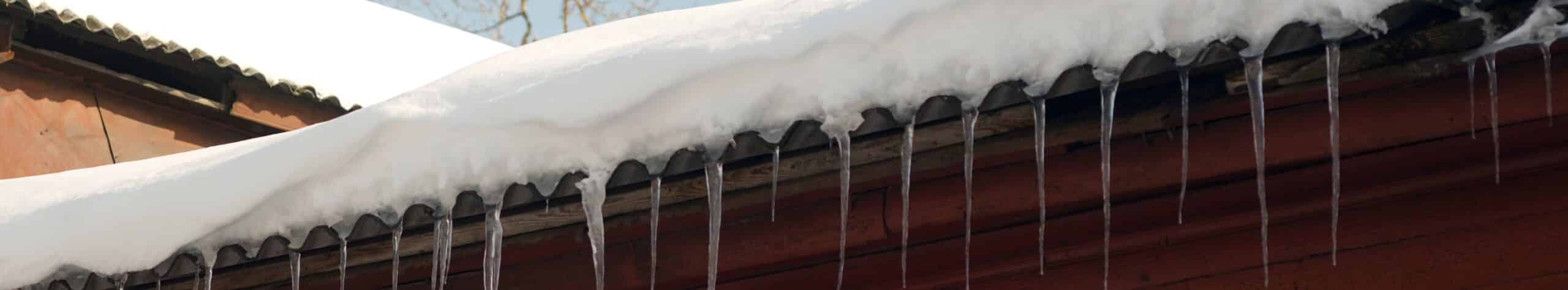 Personne déneigeant un toit.