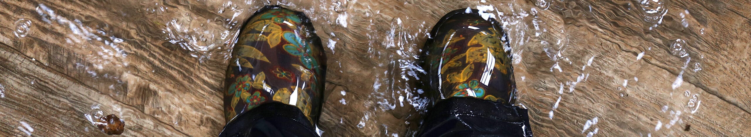 Une personne portant des bottes de pluie durant une inondation
