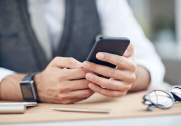 Male looking at his phone sitting