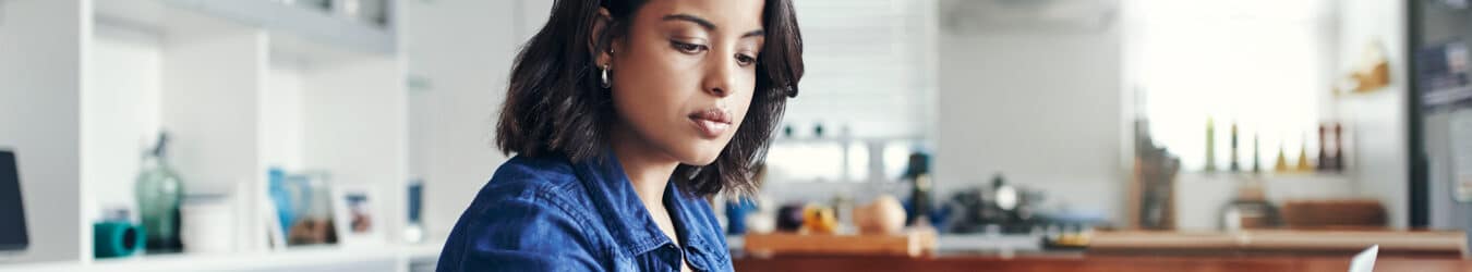 Jeune femme utilisant un ordinateur portable et passant par la paperasse