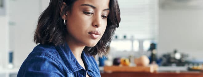 Jeune femme utilisant un ordinateur portable et passant par la paperasse