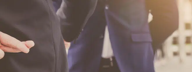 Homme d'affaires croisant ses doigts derrière son dos.