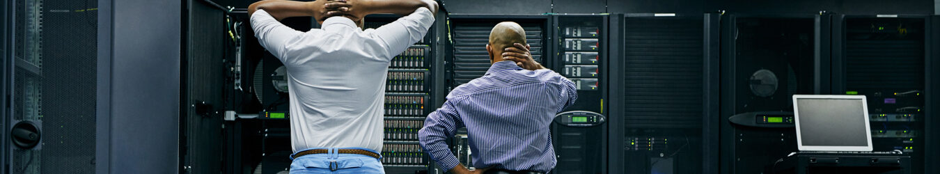 Deux techniciens informatiques réparent un ordinateur dans un centre de données.